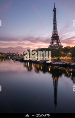 Bezaubernder Sonnenaufgang über dem Eiffelturm, Paris, mit lebhaften Reflexen auf der seine. Perfekt für Reisen, redaktionelle und Kunstdrucke Stockfoto