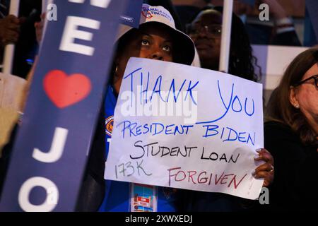 Chicago, Usa. August 2024. Eine Frau hält ein Schild, das US-Präsident Joe Biden für die Vergebung ihrer Studentendarlehen während der ersten Nacht des Democratic National Convention dankt. Quelle: SOPA Images Limited/Alamy Live News Stockfoto