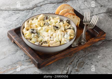 Zart cremiger Salat mit Huhn, Pflaumen, Gurke und Eiern in einer Schüssel auf dem Tisch. Horizontal Stockfoto