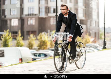 Radfahren ist der Weg zum Fortschritt! Voller Länge eines hübschen jungen Geschäftsmannes, der sich auf seinem Fahrrad freut Stockfoto