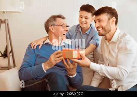Liebevoller Sohn Und Enkel Gratulieren Opa Zu Seinem Geburtstag In Der Halle Stockfoto