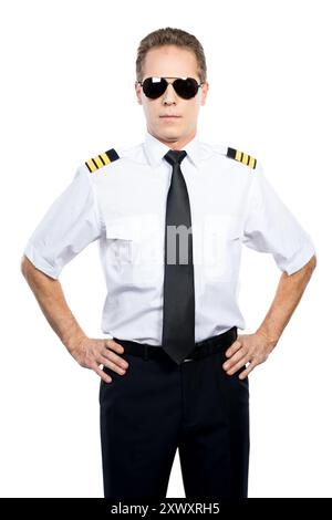 Selbstbewusster und erfahrener Pilot. Selbstbewusster männlicher Pilot in Uniform, der die Hände auf der Hüfte hält, während er vor weißem Hintergrund steht Stockfoto