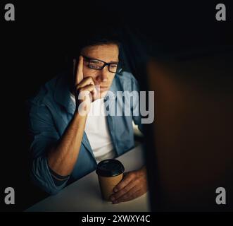 Programmierer, Computer und nachts müde mit Kaffee für Programmierung, Programmierung oder Cybersicherheit. Mann, pc und gelangweilt im Büro mit Tee für Stockfoto