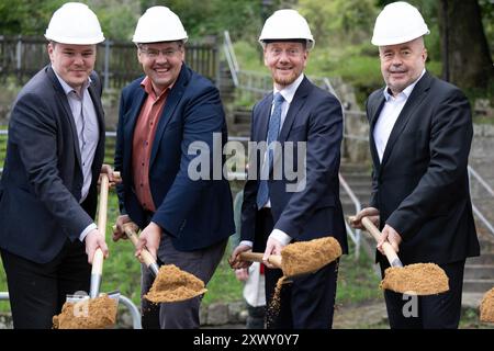 Hohnstein, Deutschland. August 2024. Fabian Funke (SPD, l-r), Bundestagsabgeordneter, Daniel Brade (unabhängiger Wählerverband), Oberbürgermeister von Hohnstein, Michael Kretschmer (CDU), Ministerpräsident von Sachsen, und Michael Geisler (CDU), Landrat Sächsisch Schweiz-Osterzgebirge, nehmen an einem symbolischen Spatenstich zur Sanierung der Burg Hohnstein Teil. Im ersten Bauabschnitt wird der Schlosspark des Felsenschlosses in der Sächsischen Schweiz mit mehr als vier Millionen Euro saniert. Quelle: Sebastian Kahnert/dpa/Alamy Live News Stockfoto