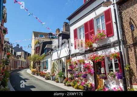 Helle Blumen vor alten traditionellen Häusern in der Rue des Moulins, St. Valery sur Somme, Somme, Picardy, Frankreich Stockfoto