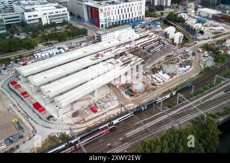 Curzon Street, Birmingham, 21. August - Züge auf der West Coast Mainline fahren entlang der HS2-Baustelle in Birmingham, da der Endbahnhof Curzon Street weiter gebaut wird. Vier der acht Gleise, die gebaut werden, sollen überflüssig werden, nachdem die Regierung weitere Strecken der Strecke aufgegeben hat. HS2 sagte, es wäre billiger für sie, die Gleise zu bauen, als nicht. Die vier ungenutzten Bahnsteige werden leer gelassen, ohne Schienen oder Signalanlagen, um unnötige Kosten für ihre Inbetriebnahme zu vermeiden. Quelle: Stop Press Media/Alamy Live News Stockfoto