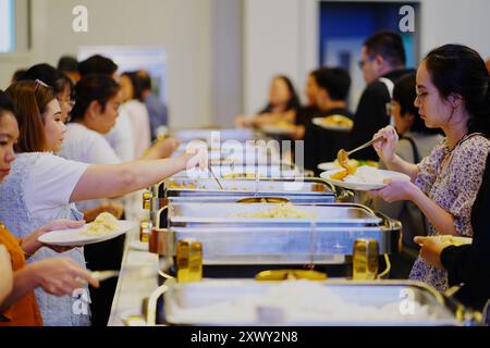 Bangkok, Thailand. August 2024. In einem Hotel in Bangkok stehen die Leute zur Mittagszeit an, um ihr Essen zu holen. (Foto: Seksan Rochanametakul/SOPA Image/SIPA USA) Credit: SIPA USA/Alamy Live News Stockfoto