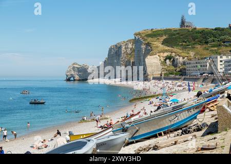 Strand von Etretat mit dem natürlichen Felsbogen von Falaise d'Amont und der Kapelle Notre-Dame de la Garde im Hintergrund Stockfoto