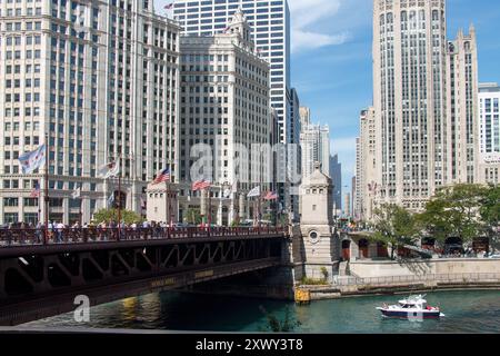 Die DuSable-Brücke über den Chicago River, eine Yacht und die Skyline mit Wrigley Building, Tribune Tower und den modernen Architekturgebäuden der Innenstadt Stockfoto