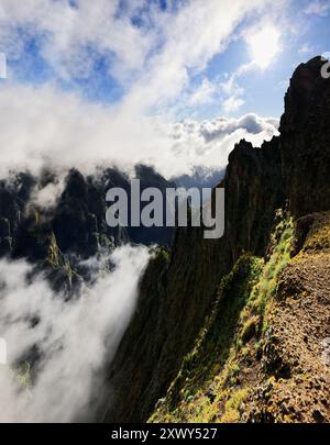 Ein vertikaler Blick auf das mit Nebel bedeckte Wandergebiet PR 1,2 Vereda do Pico Ruivo auf dem Berg Achada do Teixeira an einem sonnigen Tag in Madeira, Portugal Stockfoto