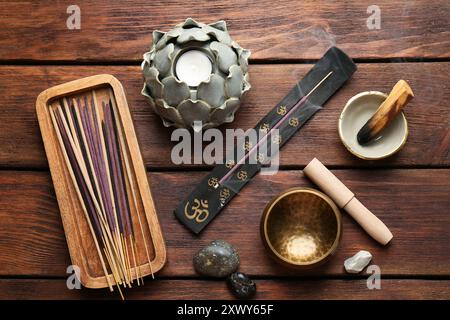 Flache Lagenkomposition mit Räucherstäbchen auf Holztisch. OM-Ligatur Stockfoto