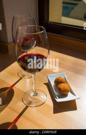 Spanischer Aperitif: Zwei Gläser Rotwein und Kroketten. Spanien. Stockfoto