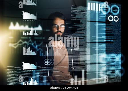 Junger Mann, Programmierer und Nacht mit Overlay auf dem Computer für Daten, zukünftige Entwicklung oder Analysen im Büro. Männliche Person, Programmierer oder Entwickler, die arbeiten Stockfoto