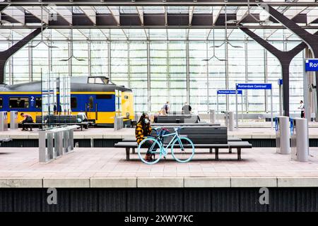 Mädchen mit Fahrrad wartend Mädchen mit Bluw Bike wartet auf dem Bahnsteig des Rotterdam Centraal Bahnhofs auf ihren Verbindungszug, während sie ihre obligatorische Gesichtsmaske aufsetzen. Rotterdam, Niederlande. Rotterdam Centraal Station Zuid-Holland Nederland Copyright: XGuidoxKoppesxPhotox Stockfoto