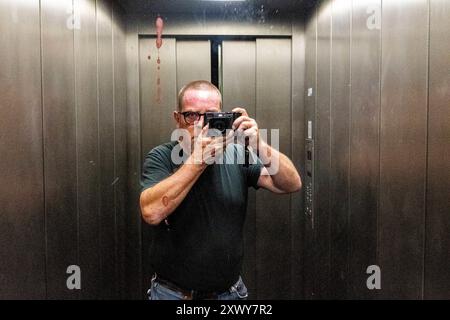 Selbstporträt Mann mit Kamera Selfie / Selbstporträt eines Reifen Erwachsenen, kaukasischer Mann in einem Aufzug. Berlin, Deutschland. MRYES Berlin Koppenstrasse Berlin Deutschland Copyright: XGuidoxKoppesxPhotox Stockfoto