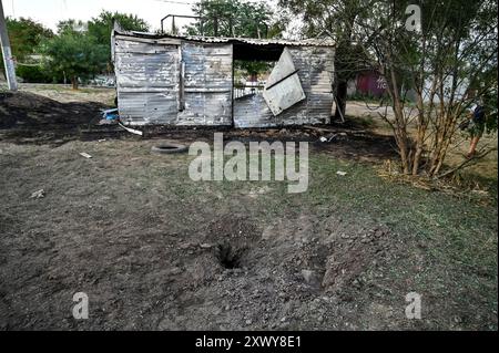 MALOKATERYNIVKA, UKRAINE - 20. AUGUST 2024 - In der Nähe des Kindercafés Levada im zentralen Park, Dorf Malokateryniwka, Region Zaporischschhia, Südostukraine befindet sich Ein Loch eines russischen Artilleriegutanschlags. Als Folge des russischen Angriffs starben zwei Menschen, darunter ein 14-jähriger Junge. Sechs Kinder sind im Krankenhaus, zwei Jungen leiden an Rückenmarkverletzungen. Stockfoto