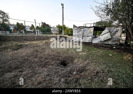 MALOKATERYNIVKA, UKRAINE - 20. AUGUST 2024 - In der Nähe des Kindercafés Levada im zentralen Park, Dorf Malokateryniwka, Region Zaporischschhia, Südostukraine befindet sich Ein Loch eines russischen Artilleriegutanschlags. Als Folge des russischen Angriffs starben zwei Menschen, darunter ein 14-jähriger Junge. Sechs Kinder sind im Krankenhaus, zwei Jungen leiden an Rückenmarkverletzungen. Stockfoto