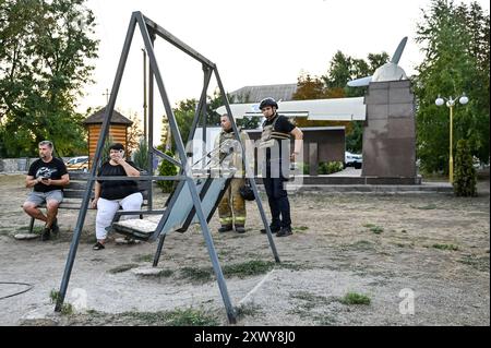 MALOKATERYNIVKA, UKRAINE - 20. AUGUST 2024 - Strafverfolgungsbehörden befinden sich vor dem Levada-Kindercafé im zentralen Park, das durch einen russischen Artilleriegutanschlag beschädigt wurde, im Dorf Malokateryniwka, Region Zaporischzhia, Südostukraine. Als Folge des russischen Angriffs starben zwei Menschen, darunter ein 14-jähriger Junge. Sechs Kinder sind im Krankenhaus, zwei Jungen leiden an Rückenmarkverletzungen. Stockfoto