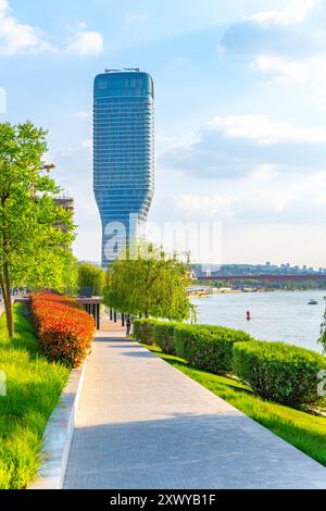 Ein herrlicher Blick auf den Belgrader Turm entlang des Flusses, umgeben von üppigem Grün und bunten Büschen, die die lebhafte Atmosphäre der Gegend an einem sonnigen Tag einfangen. Stockfoto