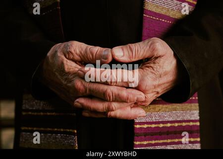 Mittlere Nahaufnahme faltiger, nicht erkennbarer männlicher Hände des Priesters Stockfoto