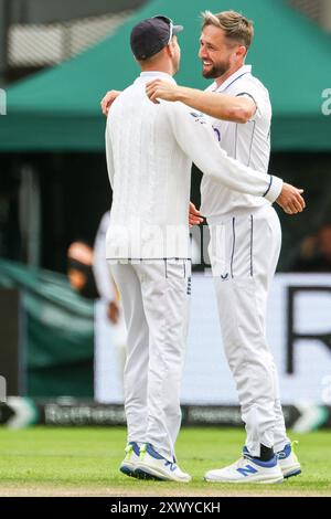 Manchester, Großbritannien. August 2024. Chris Woakes aus England (rechts) gratuliert dazu, dass er am 21. August 2024 im Emirates Old Trafford, Manchester, England, den Wicket von Nr. 21, Kamindu Mendis aus Sri Lanka, beim Spiel der Rothesay International Test Match Series zwischen England und Sri Lanka gewonnen hat. Foto von Stuart Leggett. Nur redaktionelle Verwendung, Lizenz für kommerzielle Nutzung erforderlich. Keine Verwendung bei Wetten, Spielen oder Publikationen eines einzelnen Clubs/einer Liga/eines Spielers. Quelle: UK Sports Pics Ltd/Alamy Live News Stockfoto