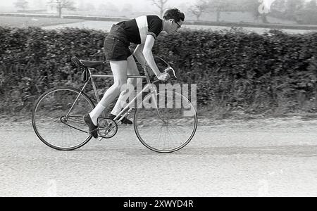 1960er Jahre, historischer junger Mann männlicher Radfahrer auf der Straße, Ersatz für Reifen im Sattel, England, Großbritannien. Fahren Sie mit einem „Southern“-Fahrrad, einem Fahrrad mit fester Ausrüstung, aus dem Sattel Stockfoto