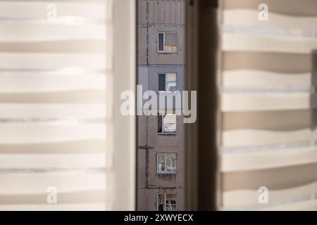 Blick vom Apartmentfenster auf ein benachbartes mehrstöckiges Paneelhaus in der Ukraine tagsüber Stockfoto