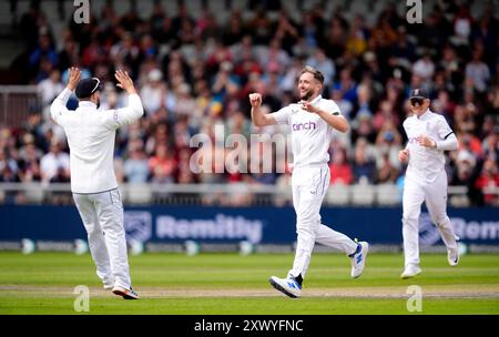 Der englische Chris Woakes feiert am ersten Tag des ersten Rothesay Test Matches im Emirates Old Trafford, Manchester, mit dem Kamindu Mendis aus Sri Lanka. Bilddatum: Mittwoch, 21. August 2024. Stockfoto