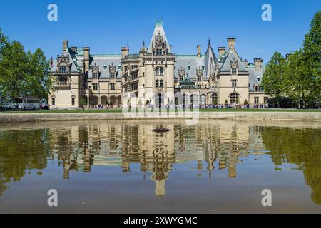 Das Biltmore House und eine Reihe von Touristen spiegeln sich im Brunnen auf dem Biltmore Estate in Asheville, NC, USA Stockfoto