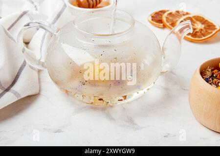 Eingießen von Bio-Bergmischung beruhigender Kräutertee. Wellness-Retreat mit Kräuteraufgüssen. Stockfoto