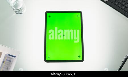 Top-Down-Ansicht eines Tablet-Computers mit Mock-Up-Chromakey-Display mit Motion Tracker-Platzhaltern. Abbildung eines Geräts auf einem Büroschreibtisch mit Business Inventory. Arbeitsplatzkonzept Stockfoto