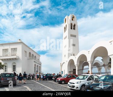 Santorin, Griechenland - 8. Oktober 2019: Eine geschäftige Straßenszene unter dem berühmten Glockenturm. Stockfoto