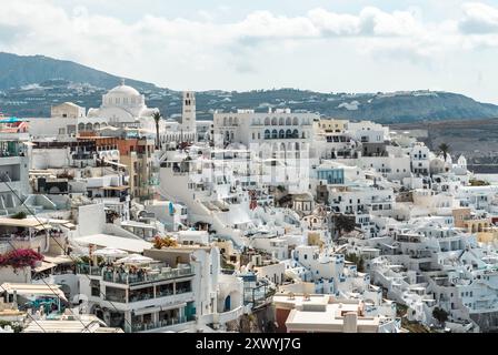 Santorini, Griechenland - 8. Oktober 2019: Weiß getünchte Gebäude mit blauen Kuppeln in Oia. Stockfoto