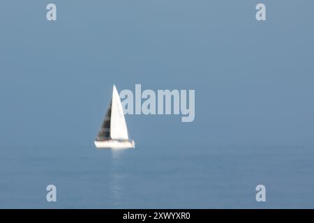 Segelboote fahren am 14. August 2024 über die Raritan Bay in der Gegend zwischen Staten Island und New Jersey. Eine lange Belichtung wurde verwendet, um Bewegungen aufzunehmen. Stockfoto