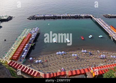 Sorrento, Italien - 24. Juni 2014: Blick aus der Vogelperspektive auf Leonellis Beach privater Badebereich in geschützter Bucht mit Liegestühlen und Sonnenschirmen auf Decks Summer Vaca Stockfoto