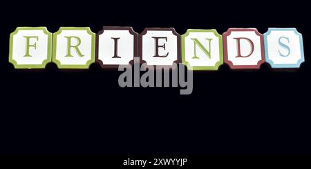 The word FRIENDS formed in block style letter on a black background, isolated. Stockfoto