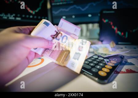 Euro-Banknote. Geld und Finanzen. Diagramme auf Bürobildschirmen. Rechner. Stockfoto