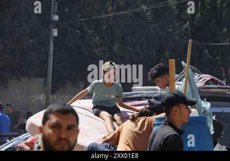 Die Palästinenser, die ihre Sachen tragen, sind auf dem Weg, in sicherere Gebiete zu wandern, nachdem die israelische Armee vor der Evakuierung gewarnt hat. Die Palästinenser, die ihre Sachen tragen, sind auf dem Weg, in sicherere Gebiete zu emigrieren, nachdem die israelische Armee vor der Evakuierung der Gebiete Abu Areef und Al-Mazra in Deir al-Balah, Gaza, am 21. August 2024 gewarnt hatte. Foto: Naaman Omar apaimages Dair EL-Balah Gazastreifen Palästinensische Gebiete 210824 Dair EL-Balah NAA 0031 Copyright: XapaimagesxNaamanxOmarxxapaimagesx Stockfoto