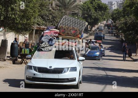 Die Palästinenser, die ihre Sachen tragen, sind auf dem Weg, in sicherere Gebiete zu wandern, nachdem die israelische Armee vor der Evakuierung gewarnt hat. Die Palästinenser, die ihre Sachen tragen, sind auf dem Weg, in sicherere Gebiete zu emigrieren, nachdem die israelische Armee vor der Evakuierung der Gebiete Abu Areef und Al-Mazra in Deir al-Balah, Gaza, am 21. August 2024 gewarnt hatte. Foto: Naaman Omar apaimages Dair EL-Balah Gazastreifen Palästinensische Gebiete 210824 Dair EL-Balah NAA 0056 Copyright: XapaimagesxNaamanxOmarxxapaimagesx Stockfoto