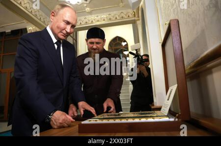 Grosny, Russland. August 2024. Der russische Präsident Wladimir Putin, links, schenkt dem tschetschenischen Führer Ramsan Kadyrow, rechts, ein Juwel verkrustet Quoran, während eines Besuchs der Propheten Isa Moschee am 20. August 2024 in Grosny, Tschetschenien, Russland. Der Überraschungsbesuch von Putin ist sein erster Besuch in der Region seit 2011. Quelle: Vyacheslav Prokofyev/Kreml Pool/Alamy Live News Stockfoto