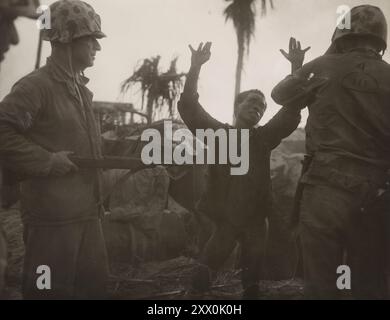 Der japanische Soldat hält die Hände hoch und erzählt seinen Marineinfängern, dass es einen anderen gibt, der Angst hat, sich aufzugeben. 1943-1945 Stockfoto