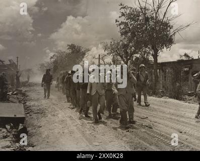 2. Weltkrieg: Schlacht von Saipan. Japan. Juni Bis Juli 1944. Gefangen genommene japanische Soldaten und Zivilisten von Saipan tragen Wasser und Nahrung für sich und ihre Gefangenen unter der Aufsicht von Marinewachen. Manche scheinen unter den gegebenen Umständen so glücklich wie möglich zu sein. Stockfoto