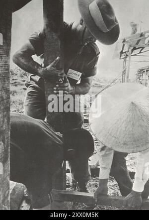 Vietnamkrieg. Der Gemeinsame Kampf: Asiatische Streitkräfte Unterstützen Südvietnamesische Truppen. Australischer Soldat hilft beim Bau von Flüchtlingshäusern. Ca. 1965-1973 Stockfoto