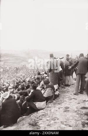 Das Leben in Palästina im frühen 20. Jahrhundert. Schwerttanz in der Prozession (Nebi Musa Prozession). Das Historische Palästina. Osmanisches Reich. 1900-1920 Nabi Musa („der Prophet Moses“, auch übersetzt als Nebi Musa) ist in erster Linie eine muslimische heilige Stätte in der Nähe von Jericho in Palästina, wo eine lokale muslimische Tradition das Grab von Moses (im Islam Musa genannt) platziert. Das Gelände befindet sich auf einer Moschee, in der sich das angebliche Grab befindet. Früher war es Schauplatz eines gleichnamigen siebentägigen religiösen Festivals, das jährlich von palästinensischen Muslimen gefeiert wurde, beginnend am Freitag vor Karfreitag im Ort Stockfoto