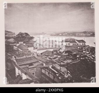 Vintage-Foto eines Teils der ausländischen Siedlung Foochow (Fuzhou). Illustrations of Qing China, 1875 Fuzhou ist die Hauptstadt und eine der größten Städte in der chinesischen Provinz Fujian. Dieses Foto ist vom oberen Ende der ausländischen Siedlung aufgenommen, mit Blick über die breite Oberfläche des Min. Dieses Bild ist wertvoll, da es den Plan eines chinesischen Hauses zeigt, das General der unteren Mittelschicht ist. Der Straßeneingang wird leider durch eine Wand verdeckt, die die linke Ecke des Vordergrundes abschneidet. Die äußere Ziegelwand der Wohnung wird auf die Höhe des Daches angehoben und eingezäunt Stockfoto