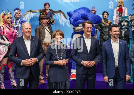 Köln, Deutschland. August 2024. Hendrik Wüst (2. V. R., CDU), Ministerpräsident von Nordrhein-Westfalen, Gerald Boese (l), Vorstandsvorsitzender der Kölnmesse, Henriette Reker (2. V. l., nicht-Partei), Bürgermeister von Köln, und Felix Falk (r), Geschäftsführer des Spieleverbandes, stehen vor Cosplayern vor der Eröffnung. Die Computer- und Videospielmesse Gamescom findet vom 21. Bis 25.08.2024 in Köln statt. Quelle: Oliver Berg/dpa/Alamy Live News Stockfoto