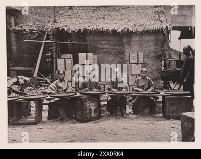 Vintage-Foto von Teepflecken im Kanton ((Guangzhou). Illustrationen von Qing China, 1875 in früheren Zeiten, bevor Hankow oder der Yangtsze-Fluss für den Außenhandel geöffnet wurde, wurde der gesamte Tee aus dem großen Tung-Ting Lake Bezirk zum Export nach Kanton gebracht. Der Großteil des Tees, der heute täglich aus Kanton verschickt wird, wird in Kwang-tung angebaut, dessen Hauptstadt die Provinz ist. Schwarze Tees, die teilweise in der Sonne getrocknet und leicht gebrannt wurden, werden entweder mit der Handfläche auf einem flachen Tablett oder mit dem Fuß in einem Hanfbeutel gerollt. Sie werden in Eisenpfannen über einem langsamen holzkohlefiff verbrannt Stockfoto