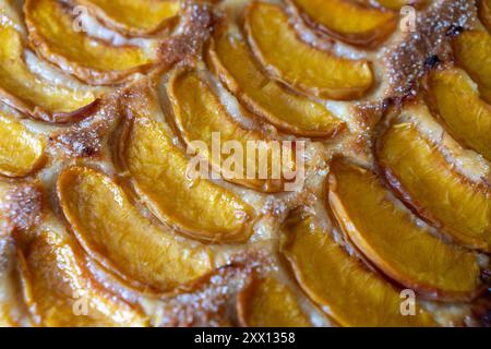 Ein Dessert aus geschnittenen Pfirsichen ist auf einem hölzernen Schneidebrett. Das Dessert ist mit Zucker bedeckt und sieht köstlich aus. Stockfoto