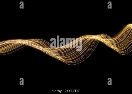 Ein Foto mit langer Belichtung. Lichtmalerei Fotografie - wirbelnde Wellen aus Neongelbgold auf schwarzem Hintergrund Stockfoto