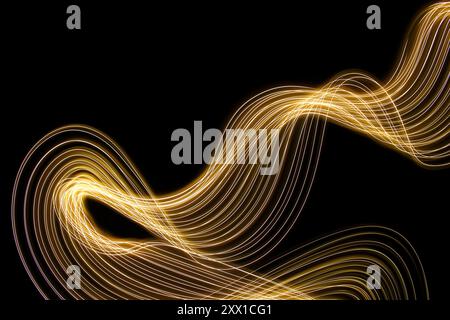 Ein Foto mit langer Belichtung. Lichtmalerei Fotografie - wirbelnde Wellen aus Neongelbgold auf schwarzem Hintergrund Stockfoto